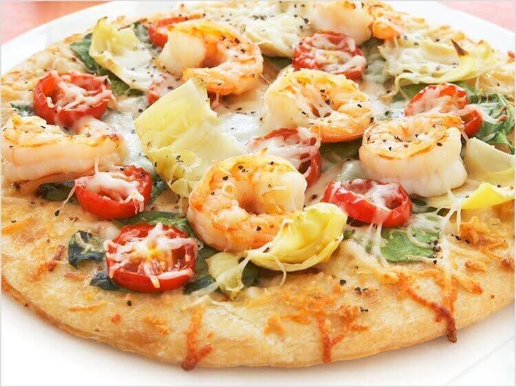 a pizza with shrimp and artichokes