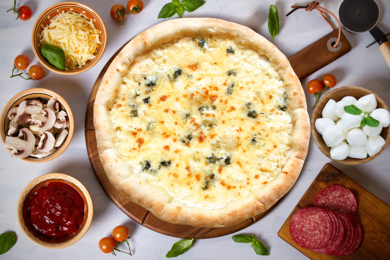 a pizza on a wooden board next to bowls of food