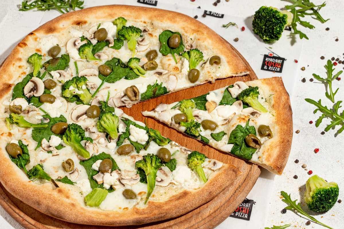 a pizza with broccoli and olives