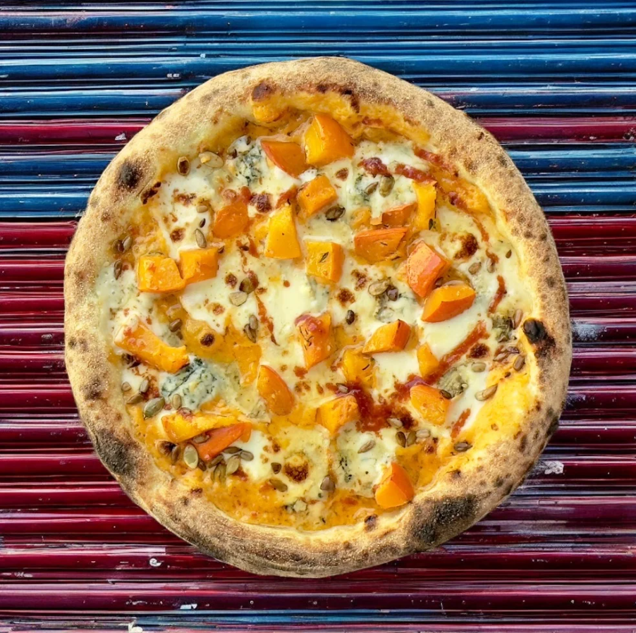 a pizza with cheese and orange toppings